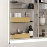 Pienen kylpyhuoneen inspiraatio, jossa on erikoisvärinen turhamaisuusyksikkö, peilikaappi valaisimilla, koristeelliset peilit sävytetyllä lasihyllyllä, valkoiset kalanruotolaatat tyylikkään ja klassisen ilmeen luomiseksi.