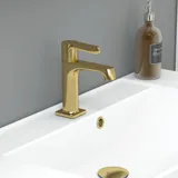 Suuri vihreä kylpyhuone, jossa allaskaappi, soikea peili kultaisella reunalla ja kauniit kehykselliset ovet