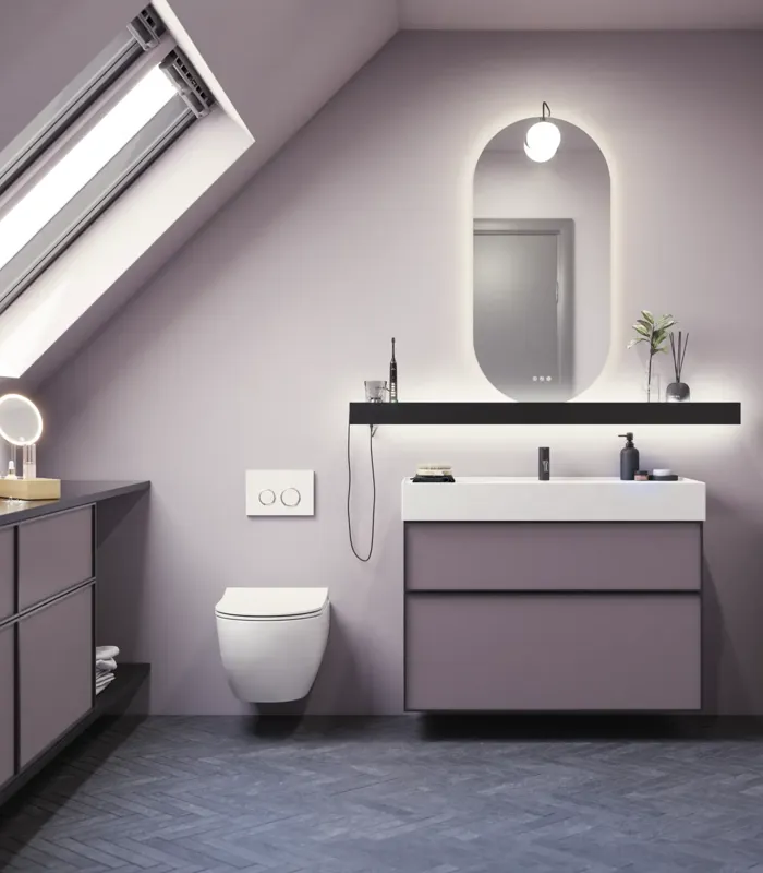 Kylpyhuone, jossa on vinot seinät, inspiraatio, kylpyhuonekalusteet liilaa, elegantit kehysovet, kaunis soikea peili lampulla, kaunis ja käytännöllinen hylly, liilaksi maalattu seinä ja harmaa kalanruotolattia, jotka antavat elegantin ja modernin ilmeen.