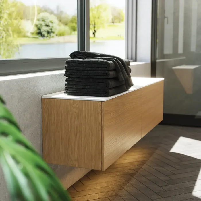 Minimalistinen ja tyylikäs kylpyhuone inspiraatio, jossa on pesuallaskaappi, alakaapit ja korkeakaapit kultaisesta tammesta, suuri pyöreä peili valaistuksella, värillinen WC ja pöytätason pesuallas