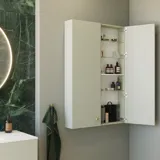 Tyylikäs ja ylellinen kylpyhuone, jossa on pehmeitä vihreitä sävyjä, suuri elegantti pyöreä peili ja moderni, hienostunut vihreä wc-istuin