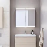 Pienen kylpyhuoneen inspiraatio, beige erikoisvärinen allaskaappi ja yläkaappi wc yläpuolella, tyylikäs peilikaappi integroidulla valolla, vaaleat värit ja valkoinen verho luovat romanttisen ja naisellisen tunnelman.