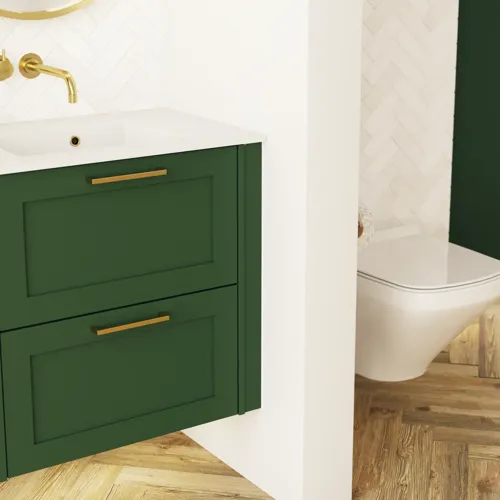 Suuri vihreä kylpyhuone, jossa allaskaappi, soikea peili kultaisella reunalla ja kauniit kehykselliset ovet