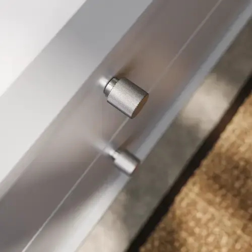 Kylpyhuone, jossa viistot seinät, harmaa allaskaappi ja yläkaappi, mittatilaustyönä tehdyt työtasot, moderni nelikulmainen pöytätason pesuallas, nelikulmainen peili valoilla, paljaat betoniseinät ja lattiat luovat urbaanin ilmeen