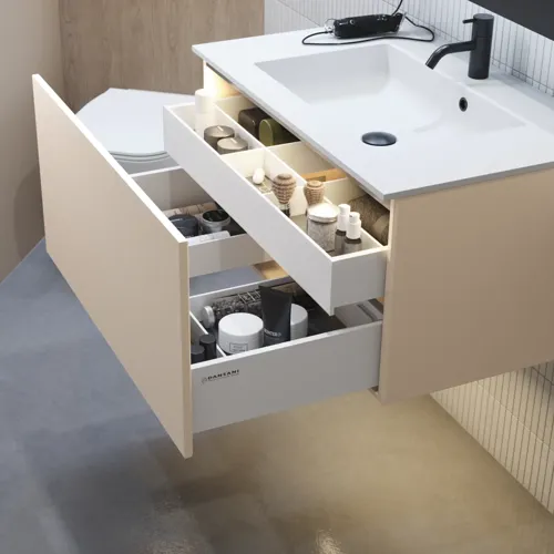 Tyylikäs kylpyhuone inspiraatio beige pesuallaskaapilla, jossa on sisälaatikko, yläkaappi, avoin hylly, soikea peili valaistuksella, yhteensopivat riippuvalaisimet, hylly peilin alla ja seinään kiinnitetty WC. Vaaleat, pitkät laatat seinillä