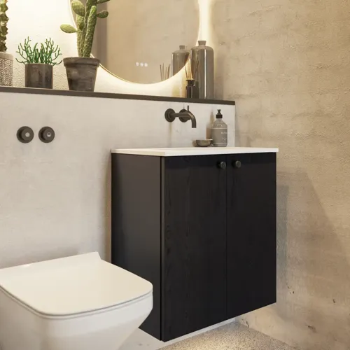 Kylpyhuoneen inspiraatio, jossa on mustasta tammesta valmistettu pesuallaskaappi, elegantti pyöreä peili ja pesuallas, tyylikkäät tarvikkeet sekä kaktuskasvit ja seinät raaka-aineista antavat karkeaa, teollista ja urbaania ilmettä.